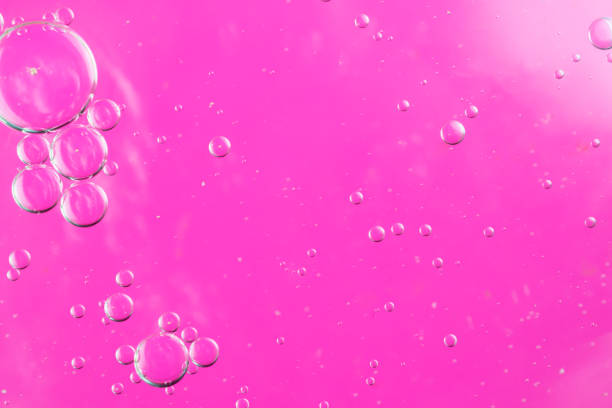 istock oil drops on water on a pink background 1295311322