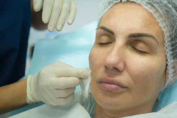 istock Plastic surgeon preparing for operation on woman face 1295311512