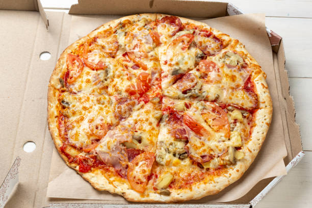 istock Pizza in a cardboard box against a white background. View from above. Pizza delivery. 1295311881