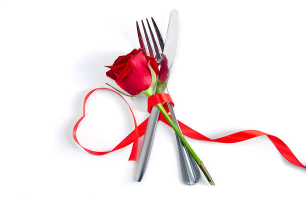 istock Fork and knife, red rose tied red ribbon 1295314748
