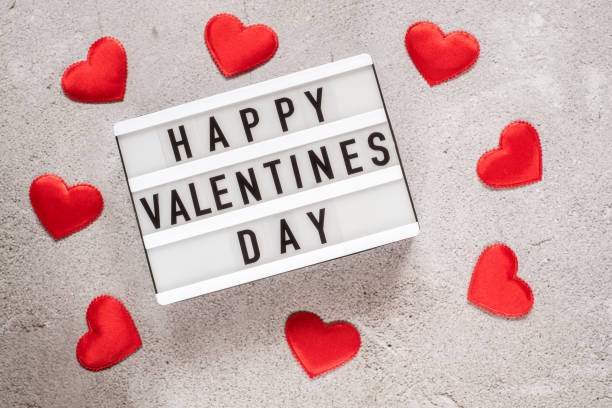 istock Valentine's day layout with lightbox with red heart glitter on cement background 1295315059