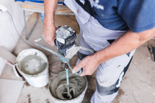 istock Mixing concrete and glue with tile adhesive mixing machine 1295316934
