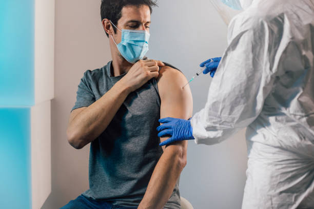 istock Man with face mask getting vaccinated, coronavirus concept. 1295317240