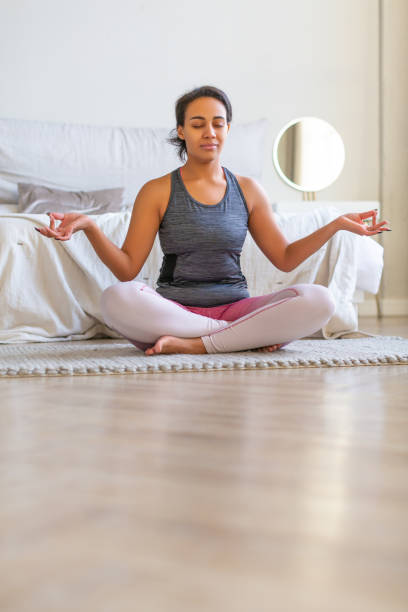 istock African American woman meditating while doing yoga 1295319090