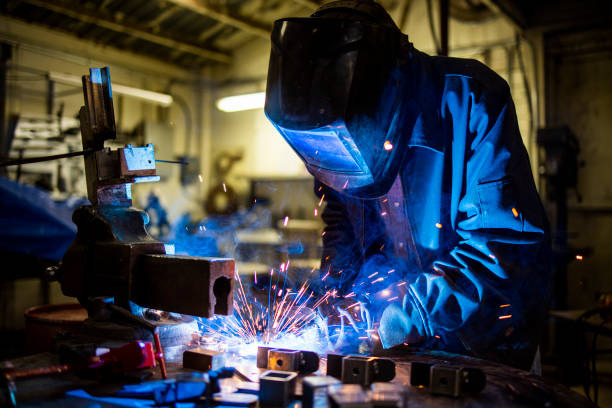 Senior man welding farming equipment stock photo