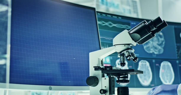 istock Laboratory equipment, microscope and computers. Brainwave research on screens. Side view of scientist 1295324844