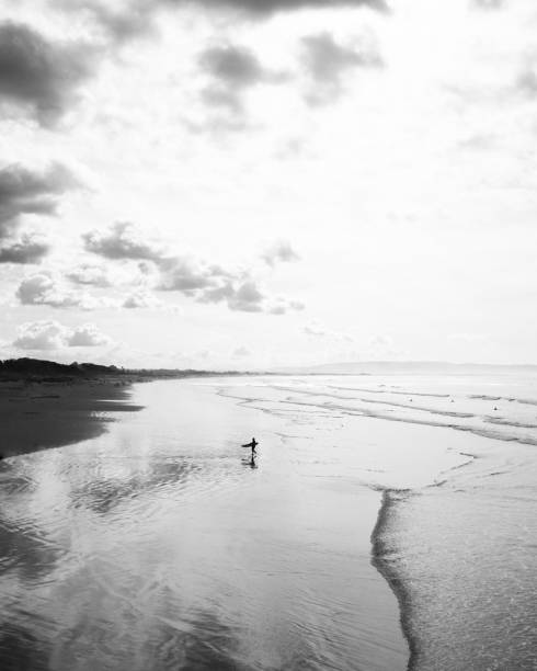 istock Solo surfer walking on the beach 1295327055