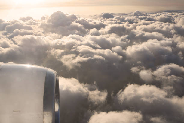 view of jet plane wing on the background of thick clouds and blue sky.