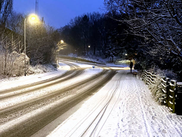 Woman walking an empty street a covered with snow