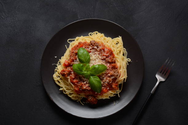 istock Plate of pasta Bolognese on dark background, 1295331430