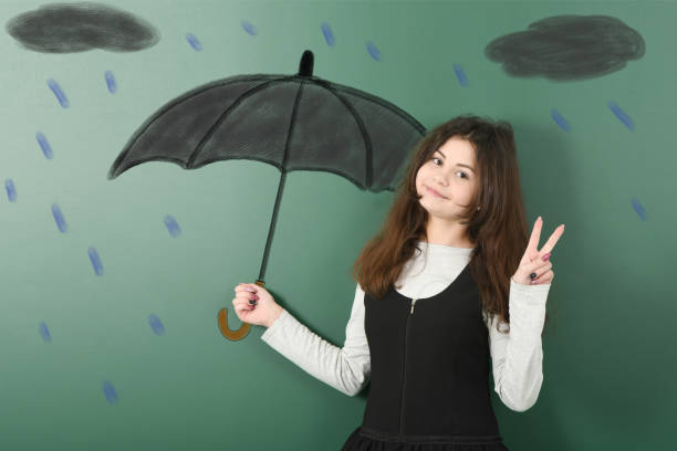 istock Pre-adolescent girl holding painted black umbrella 1295334541