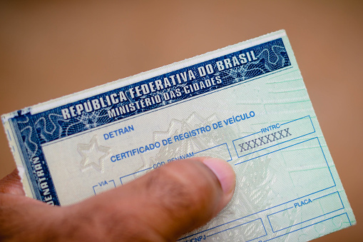 Hombre posee certificado de registro de vehículo (CRV). Es el documento emitido anualmente para indicar que el coche es capaz de moverse por las calles de Brasil photo