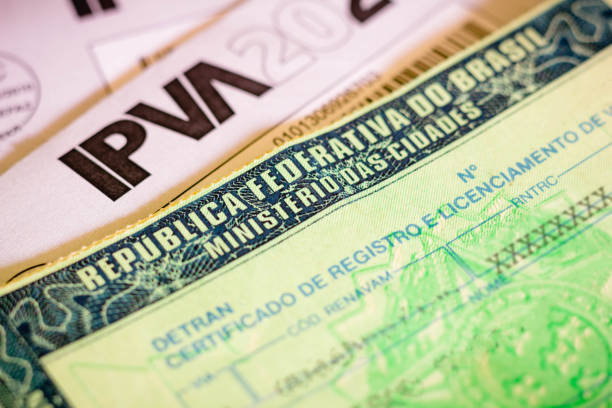 istock Man holds vehicle registration and licensing certificate (CRLV). It is the document issued annually to indicate that the car is able to move through the streets of Brazil 1295336752