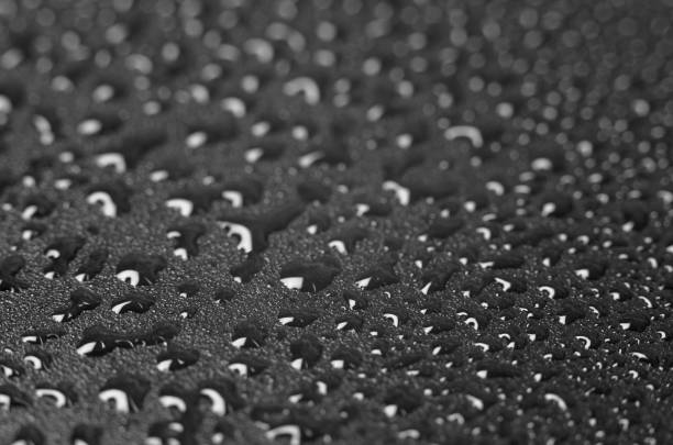 istock Crystal drops of water on a black background 1295338818