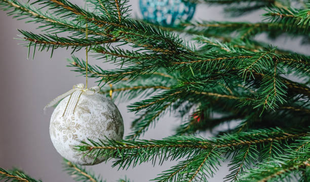istock Christmas tree toy white ball with golden patterns hanging on the tree 1295342845