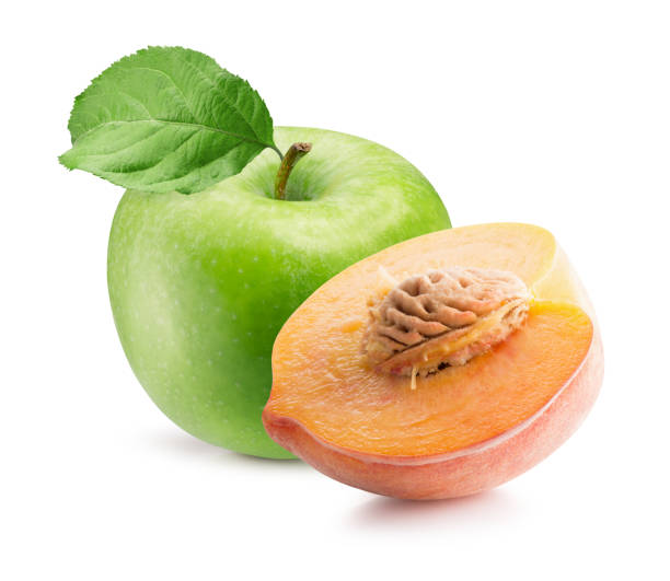 istock green apple with leaf and half of peach isolated on a white background 1295343962