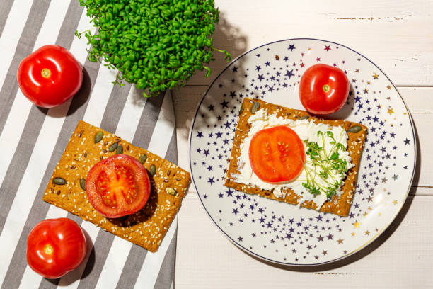 istock Sandwich with soft cheese, tomatoes, microgreens on the plate. Flat lay. 1295346802