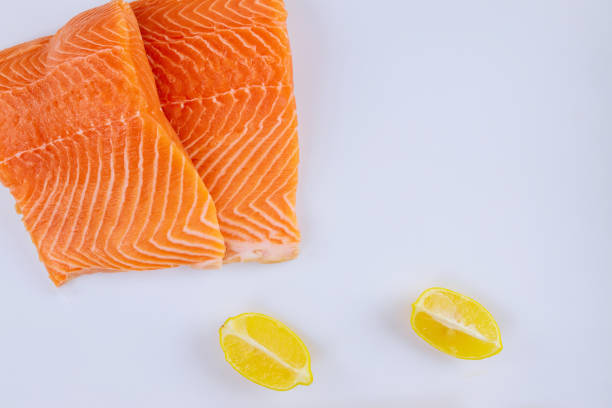 istock Two fillets raw salmon with lemon on white background 1295348297