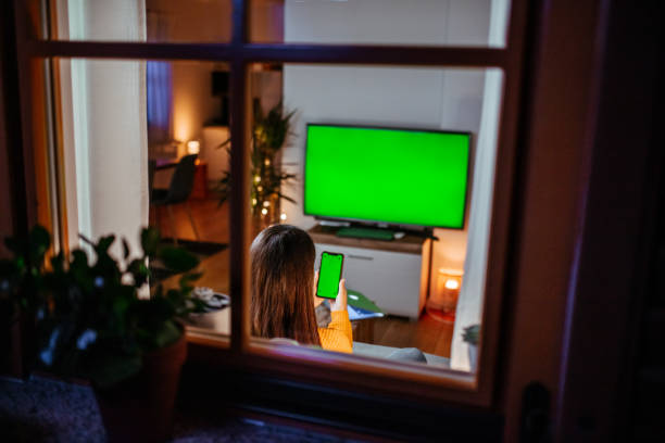 istock Woman holding mobile phone at home 1295348970