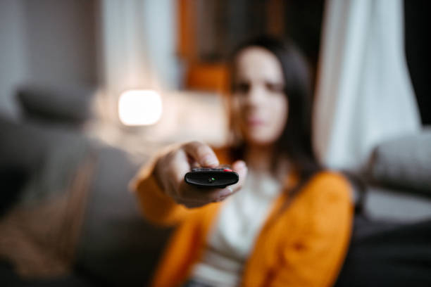 istock Woman holding tv remote 1295349935