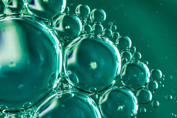 istock oil drops on water on blue background 1295356401