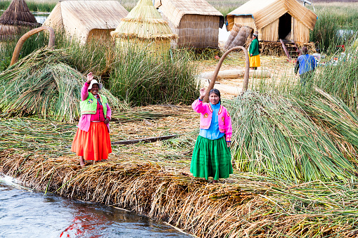 Lake Titicaca, Peru - January 12, 2020: Indigenous People on self-fashioned floating island in Lake Titicaca near Puno.