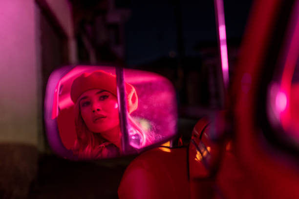 Young woman night looking in the car mirror