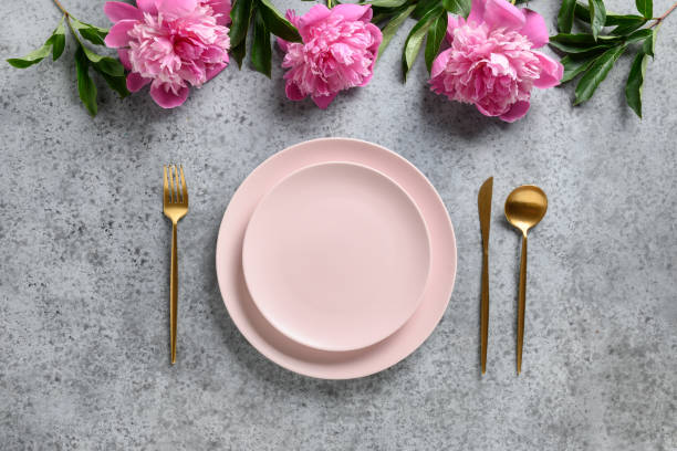 istock Elegance table setting with peony flowers on grey stone. Top view. 1295362691