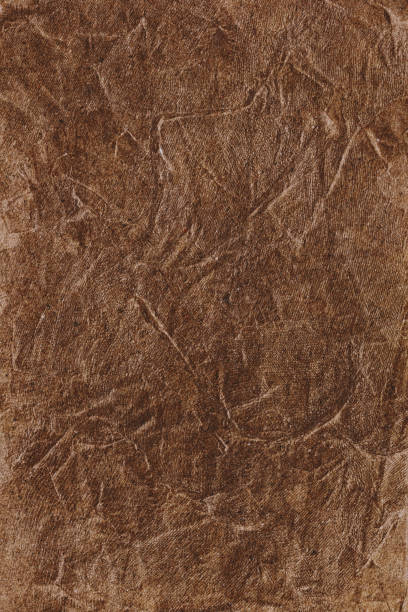 istock Textured handmade brown textile background with mesh and paper base 1295365786