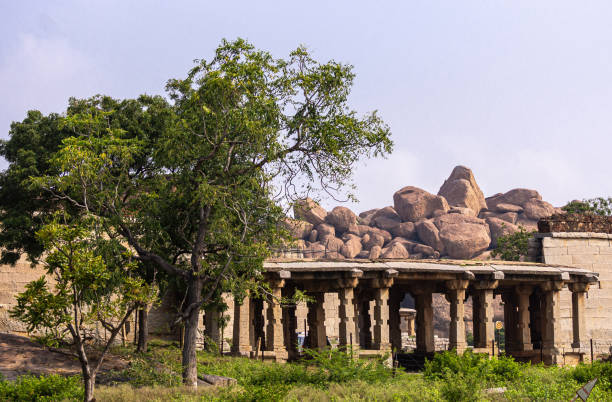 Badavilinga Temple in its natural environment, Hampi, Karnataka, India. Hampi, Karnataka, India - November 5, 2013: Badavilinga Temple in its natural environment of green vegetation and huge brown boulders. Small ruinous brown stone temple building. lingam yoni stock pictures, royalty-free photos & images