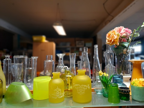 Closeup of Hypericum flowers on a table, with a jar of homemade St. John's wort oil in the background