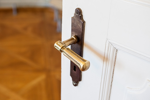 Wide open white door with brass handle