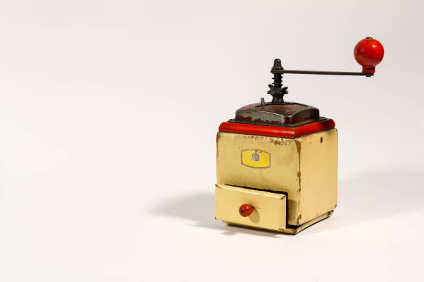 istock Old wooden colored manual coffee grinder with red handle, on white background, with copy space 1295378753