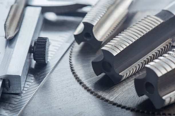 istock set of different drill bits,thread tap and mill cutters with caliper ruler on steel plate background. Locksmithing deal. 1295380028