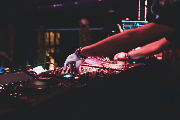istock dj mixing music in the disco 1295383624