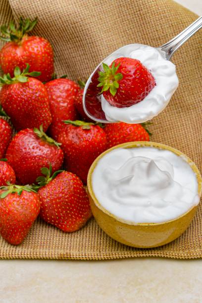 istock Strawberry on spoon with whipped cream 1295384795