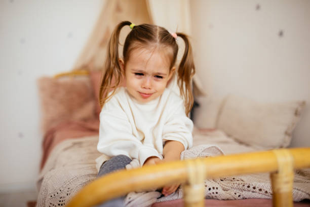 istock Crying little girl in bed 1295385562