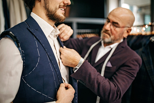 Senior salesman measuring length of sleeve for customer