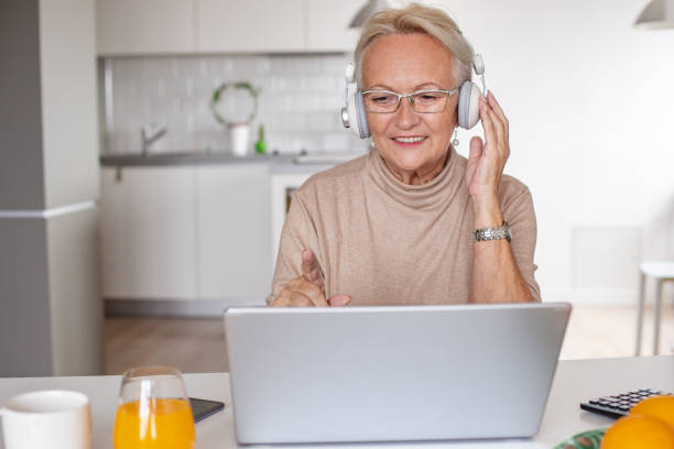 istock Senior woman using laptop at home 1295385650