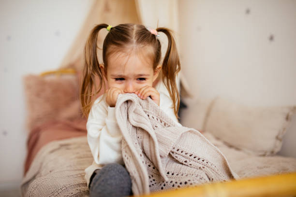 istock Crying little girl in bed 1295385702