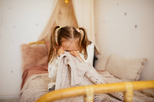 Crying little girl in bed Portrait of unhappy small girl indoors, crying. fear stock pictures, royalty-free photos & images