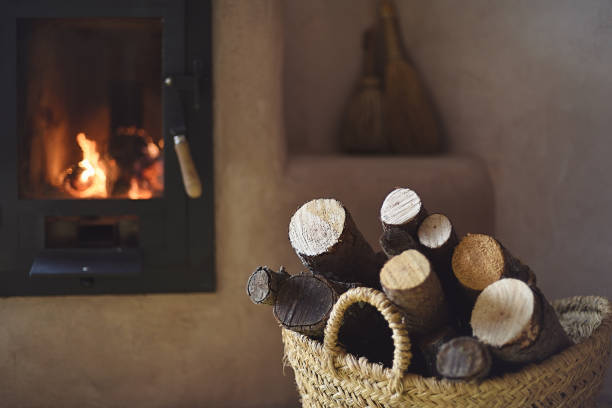 istock Wicker basket with firewood and stove lit at home 1295386431