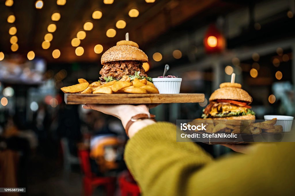 Delicious meal Woman carrying burger Restaurant Stock Photo