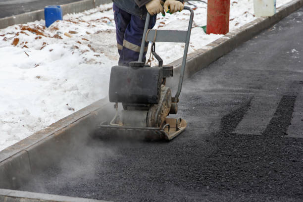 istock Worker use vibratory plate compactor for ramming asphalt. Men at work. Laying new asphalt pavement on the road. 1295388164