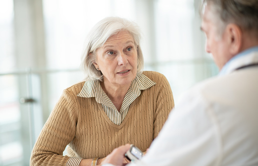 A senior female of Caucasian ethnicity is talking to her medical provider about her options for her medical treatment.