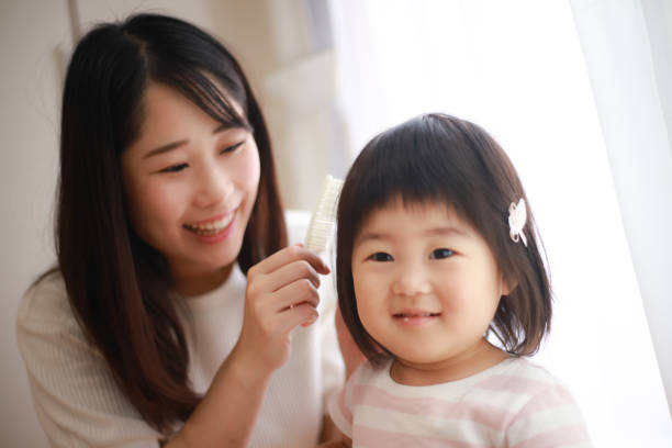 Girl having her hair combed