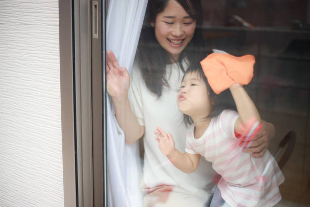 istock Parents and children cleaning windows 1295394054