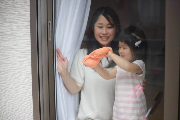istock Parents and children cleaning windows 1295394573