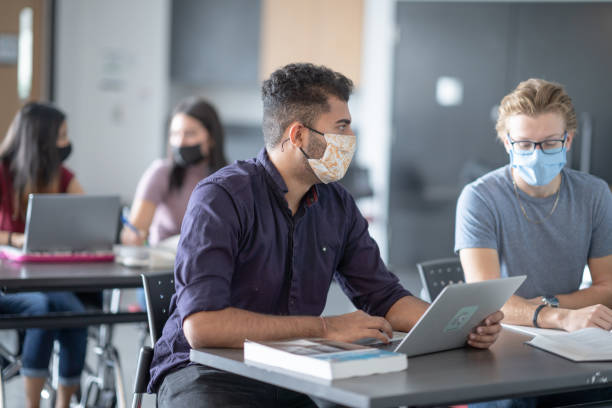 istock Students wearing face mask in classroom 1295398388