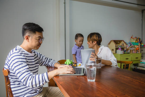 istock Happy moments young Asian family working with digital tablet and laptop computer while sitting in living room, Family relaxing and spending time together at home, Working from home concept 1295402122